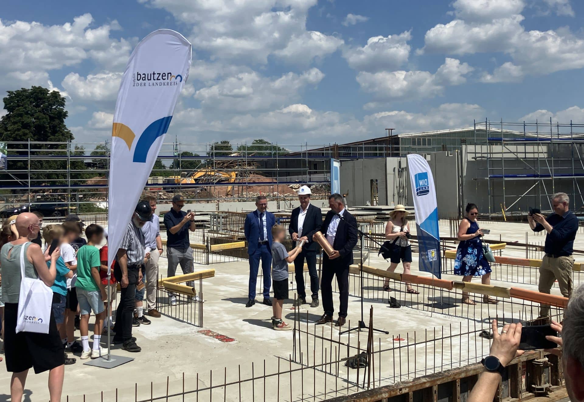 Unter Beisein von Vertretern aus Politik, der Bauwirtschaft, den Medien und Vertreterinnen und Vertretern der Schule wurde die traditionelle Zeitkapsel in das Fundament eingemauert. Foto: hpm